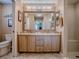Bathroom featuring double sinks with granite countertops, a large mirror, and walk-in shower at 1206 Thompson Ave, The Villages, FL 32162