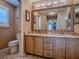 Bright bathroom with double sinks, a decorative mirror, and a nearby toilet at 1206 Thompson Ave, The Villages, FL 32162