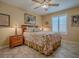 Comfortable bedroom with a ceiling fan, shuttered window, and matching bedside lamps at 1206 Thompson Ave, The Villages, FL 32162