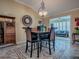 Dining area features a dark wood table set for four with adjacent living space at 1206 Thompson Ave, The Villages, FL 32162