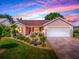 Charming single-story home featuring a well-manicured lawn, tasteful landscaping, and a two-car garage at 1206 Thompson Ave, The Villages, FL 32162