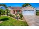 Charming single-story home featuring a well-manicured lawn, tasteful landscaping, and a two-car garage at 1206 Thompson Ave, The Villages, FL 32162