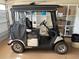 View of the included Yamaha golf cart with durable tires, custom seats, and weatherproof enclosure at 1206 Thompson Ave, The Villages, FL 32162