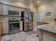Modern kitchen featuring stainless steel appliances, granite countertops, and neutral-toned cabinets at 1206 Thompson Ave, The Villages, FL 32162