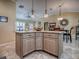 Kitchen island with granite countertops, barstool seating, and overhead lighting adjacent to the dining area at 1206 Thompson Ave, The Villages, FL 32162