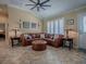 Comfortable living room features a leather sectional, vaulted ceiling, and neutral decor at 1206 Thompson Ave, The Villages, FL 32162