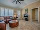 Cozy living room with a large leather sectional, ceiling fan, and tiled floors at 1206 Thompson Ave, The Villages, FL 32162