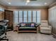 Bright living room featuring large windows with plantation shutters, comfortable seating, and tile floors at 1206 Thompson Ave, The Villages, FL 32162
