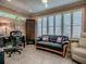 Bright living room featuring large windows with plantation shutters, a desk, and comfortable seating at 1206 Thompson Ave, The Villages, FL 32162