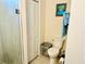 Bathroom featuring toilet, tiled shower, storage closet, and tiled floors at 12077 Lakeshore Way, Oxford, FL 34484