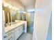 Stylish bathroom with a large mirror, single sink vanity, and a glass-enclosed shower at 12077 Lakeshore Way, Oxford, FL 34484