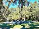 Community gardens with raised garden beds and greenery surrounded by mature trees and blue sky at 12077 Lakeshore Way, Oxford, FL 34484