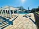 Community pool area featuring lounge chairs, tables, umbrellas, and clear blue swimming pool at 12077 Lakeshore Way, Oxford, FL 34484