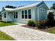 A beautiful single story home featuring large windows, a metal roof, and a patterned brick walkway at 12077 Lakeshore Way, Oxford, FL 34484