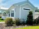 Charming single-Gathering home featuring light gray siding, white trim, and well-maintained landscaping at 12077 Lakeshore Way, Oxford, FL 34484
