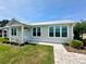 Attractive single-Gathering home featuring a metal roof and lush landscaping at 12077 Lakeshore Way, Oxford, FL 34484