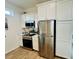 Modern kitchen features stainless steel appliances, plank flooring, and stone countertops at 12077 Lakeshore Way, Oxford, FL 34484