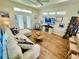 Comfortable living room featuring a ceiling fan, plank flooring, and bright natural lighting at 12077 Lakeshore Way, Oxford, FL 34484