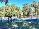 Community pickleball courts surrounded by mature trees provides a shaded recreational space at 12077 Lakeshore Way, Oxford, FL 34484