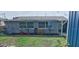 Well-maintained backyard featuring lush grass, vibrant plants, and a charming gray house with white-trimmed windows at 1224 Lakeview Dr, Clermont, FL 34711