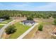 High aerial perspective highlighting the home's architectural design, landscaping, and location near wooded area at 12565 Cynthia Ln, Clermont, FL 34715