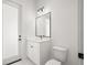 Well-lit bathroom featuring white cabinetry, modern fixtures, and convenient access to the outside at 12565 Cynthia Ln, Clermont, FL 34715