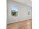 Bright bedroom with light hardwood flooring and two large windows with a view at 12565 Cynthia Ln, Clermont, FL 34715