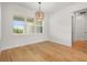 Bright dining room featuring a modern light fixture, large window, and wood floors at 12565 Cynthia Ln, Clermont, FL 34715