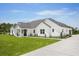 Exterior of a stunning modern farmhouse featuring lush green lawn, landscaping, and a concrete driveway at 12565 Cynthia Ln, Clermont, FL 34715