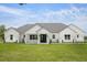 Modern farmhouse exterior showcasing a well-manicured lawn and black trimmed windows and doors at 12565 Cynthia Ln, Clermont, FL 34715