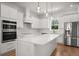 Modern kitchen with stainless steel appliances, white cabinets, and a large center island at 12565 Cynthia Ln, Clermont, FL 34715