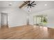 Open concept living room showcasing wood flooring, a modern ceiling fan, and access to the patio at 12565 Cynthia Ln, Clermont, FL 34715