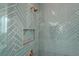 Close up of the shower showcasing the herringbone tile and bronze fixtures at 12565 Cynthia Ln, Clermont, FL 34715