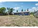 Expansive backyard with a gray home, offering ample space for outdoor activities and potential landscaping at 1406 Hope Ct, Tavares, FL 32778