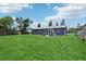 Spacious backyard featuring lush green grass and a modern home exterior at 1406 Hope Ct, Tavares, FL 32778