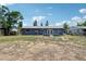 Backyard view of the gray home with white trim, showcasing its patio and surrounding green space at 1406 Hope Ct, Tavares, FL 32778