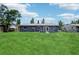 Spacious backyard featuring lush green grass and a modern home exterior at 1406 Hope Ct, Tavares, FL 32778