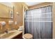 Cozy bathroom with essential fixtures, featuring a shower with a patterned curtain at 1406 Hope Ct, Tavares, FL 32778