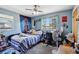 A bedroom with blue walls, a ceiling fan, and one window with natural light at 1406 Hope Ct, Tavares, FL 32778