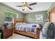 A bedroom with green walls, a ceiling fan, and two windows with natural light at 1406 Hope Ct, Tavares, FL 32778