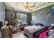 A casual bedroom with painted walls, a ceiling fan, and a bed with a black and pink comforter at 1406 Hope Ct, Tavares, FL 32778