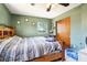 Bedroom with a wooden bed frame, ceiling fan, closet, and a window providing natural light at 1406 Hope Ct, Tavares, FL 32778