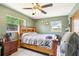 Relaxing bedroom featuring a wooden frame bed, neutral bedding, and a fan for comfort at 1406 Hope Ct, Tavares, FL 32778