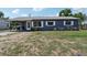 View of a single story home with gray exterior, white trim, metal roof and car port at 1406 Hope Ct, Tavares, FL 32778