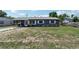 Charming single-story home with gray exterior, metal roof, and well-maintained yard at 1406 Hope Ct, Tavares, FL 32778