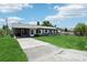 Charming home with well-maintained lawn, metal roof, long driveway, and white-trimmed windows at 1406 Hope Ct, Tavares, FL 32778