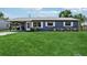 Quaint home featuring a well-kept front lawn, metal roof, and white-trimmed windows at 1406 Hope Ct, Tavares, FL 32778