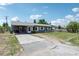 View of the property showing the driveway, yard, and the front of the gray single-story home at 1406 Hope Ct, Tavares, FL 32778