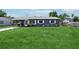 Well-manicured front lawn leading up to a gray home with a metal roof and covered parking at 1406 Hope Ct, Tavares, FL 32778
