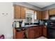 Kitchen featuring wooden cabinets and black appliances, a functional and appealing space at 1406 Hope Ct, Tavares, FL 32778